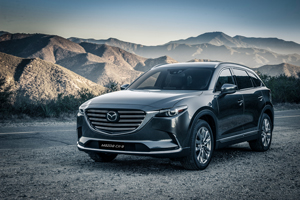Mazda CX-9 SUV parked in mountain scenery, showcasing Mazda design strength and safety confidence.